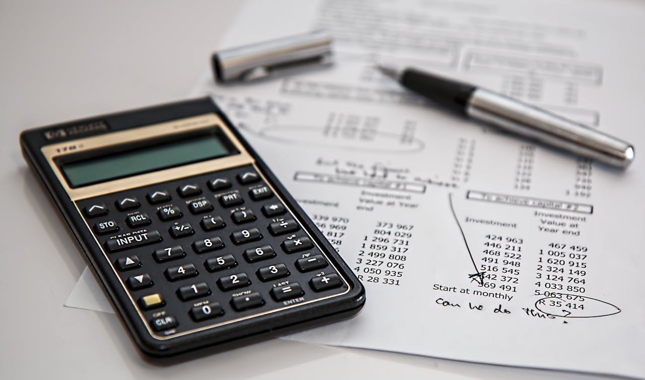 Close-up of financial documents with calculator and pen, ideal for business management themes.